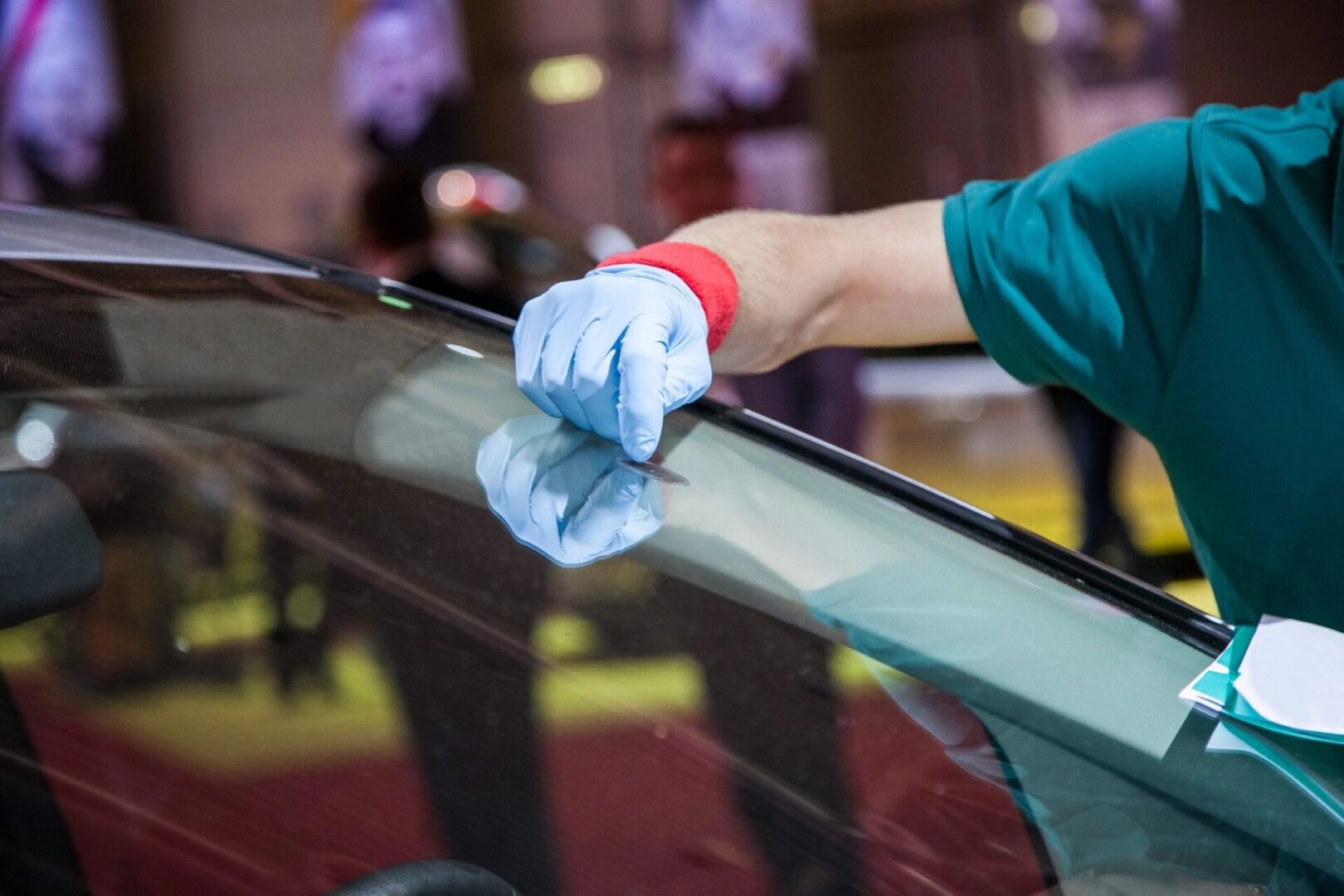 A person with gloves on working on a car.