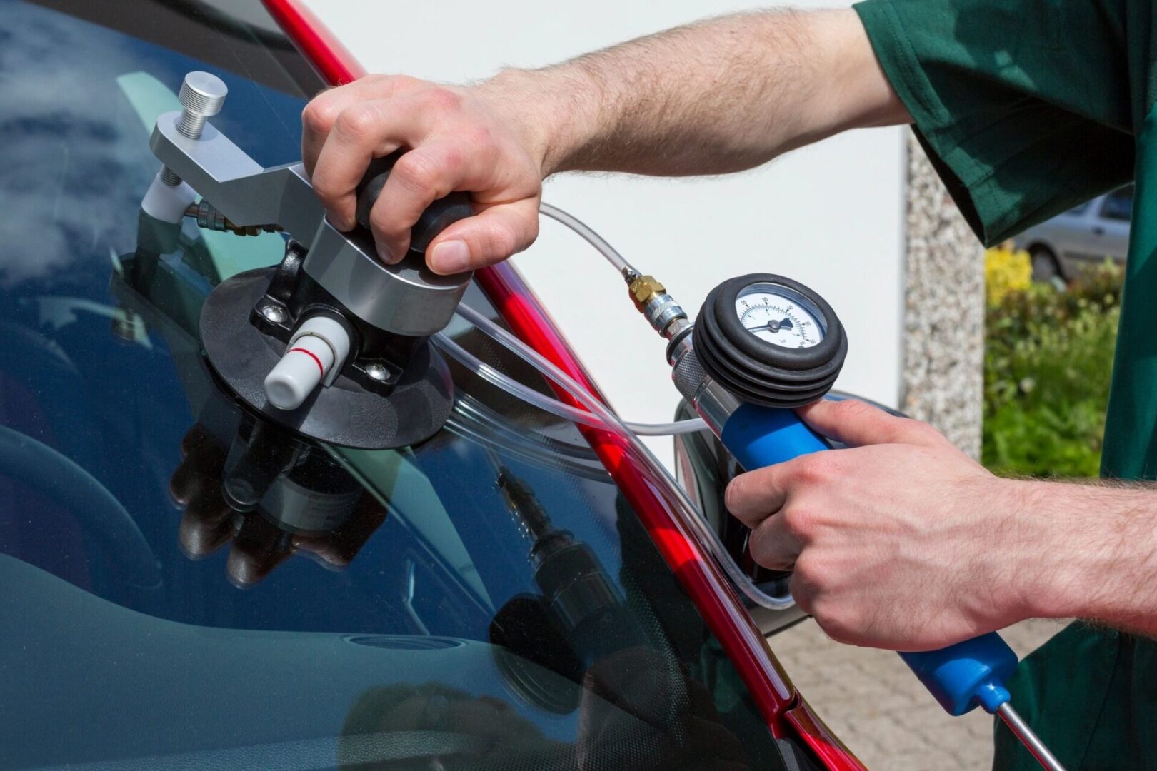 A person is using an air pump to inflate the windshield of their car.